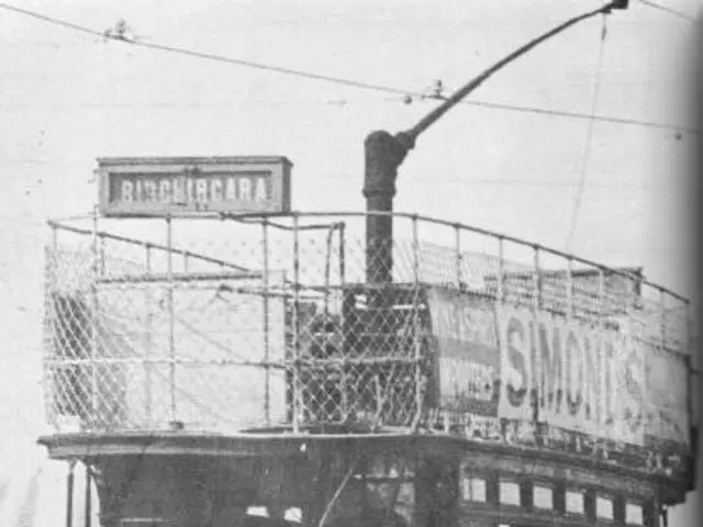 The image shows an old black and white photo of a tram on the tracks, with a few people inside the...