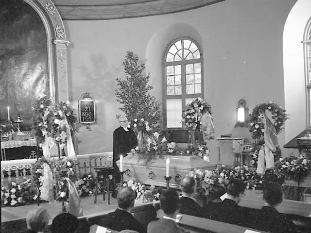 The image shows a black and white photo of a funeral home, with a group of people sitting on...
