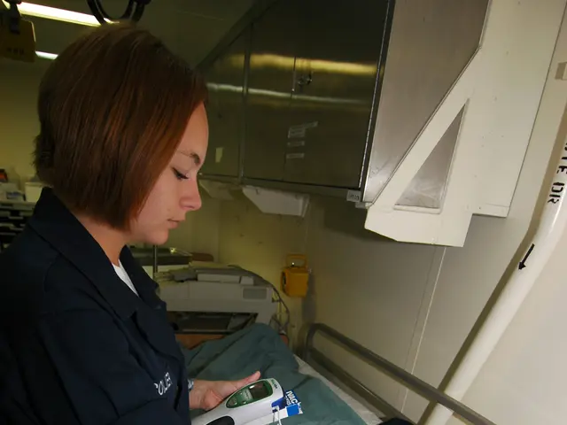 The image shows a man laying in a hospital bed with a nurse standing beside him, holding an...