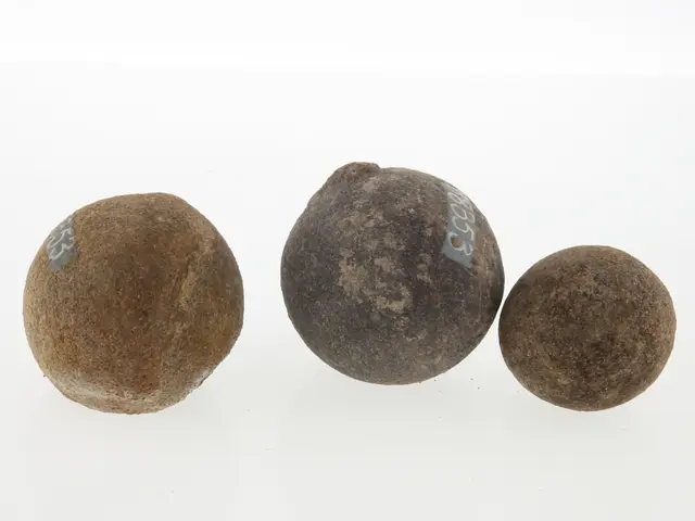 The image shows three old metal balls on a white surface. The balls are brown in color and have...