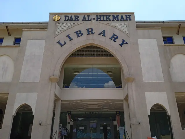 The image shows the Dar Al-Hikmah Library in Dubai, UAE. It is a large building with glass walls...