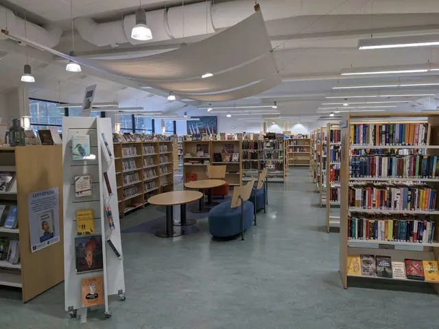 The image shows a large library filled with lots of books on the racks, tables, chairs, sofas,...