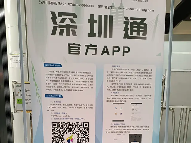 The image shows a banner with a QR code on it in front of a building, surrounded by stands, boards,...