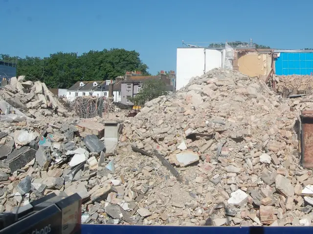 The image shows a large pile of rubble in the middle of a construction site, surrounded by...