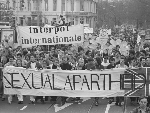 The image shows a group of people walking down a street, holding a banner that reads "Sexual...