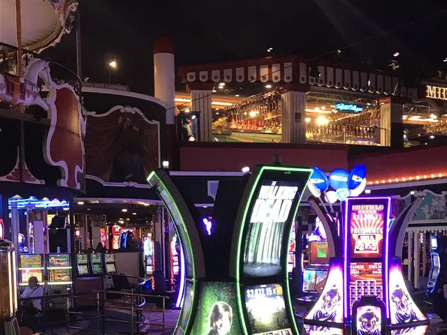 The image shows a group of people playing slot machines in a casino at night, illuminated by the...