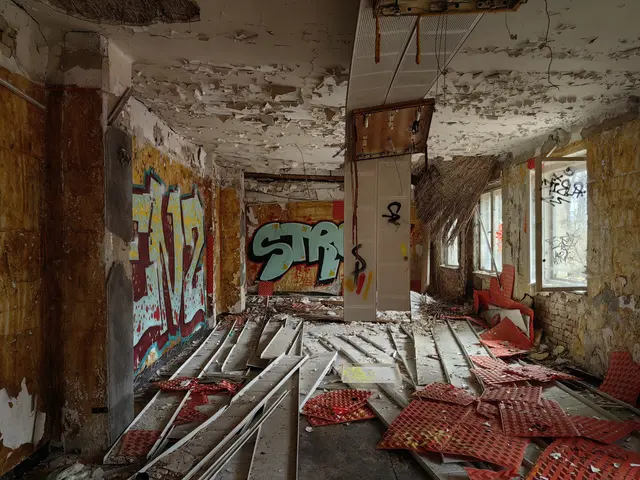The image shows an abandoned building with graffiti on the walls. The floor is littered with metal...