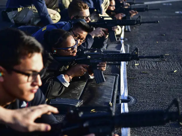The image shows a group of people sitting on the ground, each holding a rifle, with bullets...