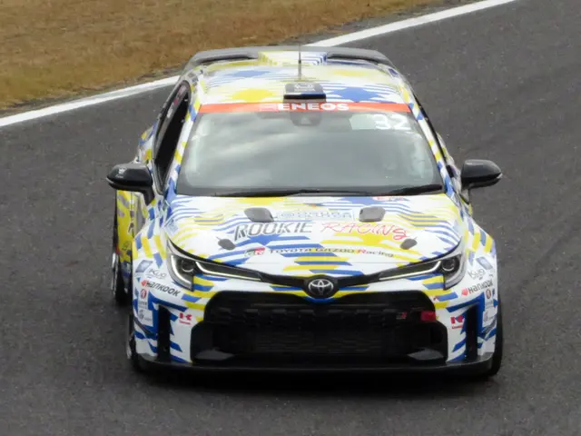 The image shows a Toyota Camry GT3 race car driving on a race track, with text on the car and grass...