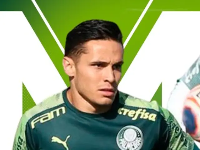 The image shows a man in a green t-shirt running with a soccer ball in his hand. He appears to be...