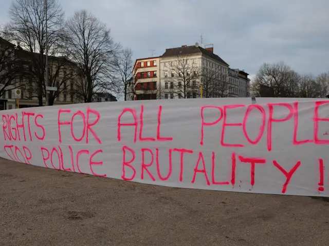 The image shows a group of people standing on the ground, holding a banner that reads "Rights for...