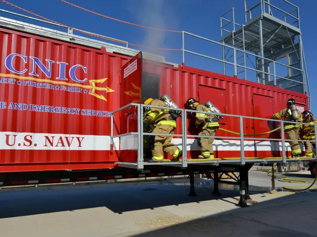 The image shows a group of firefighters wearing helmets and holding pipes, standing on top of a red...