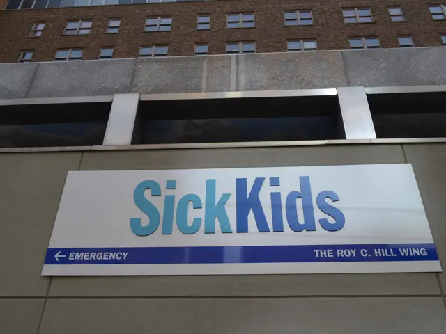 The image shows a building with a sign that reads "Sick Kids" on the side of it. The building has...