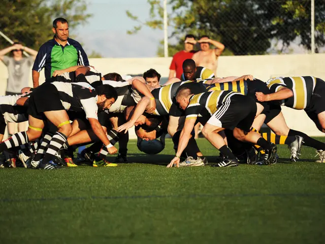 The image shows a group of men playing a game of rugby on a grassy field, with a ball in the...