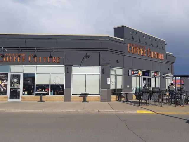 The image shows a coffee culture coffee shop on the corner of a street, with a road in the...