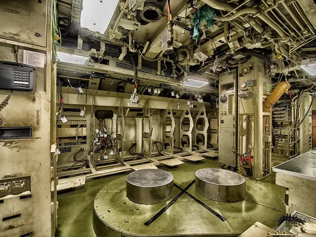 The image shows the inside of a submarine with a lot of equipment, including two round tables on...