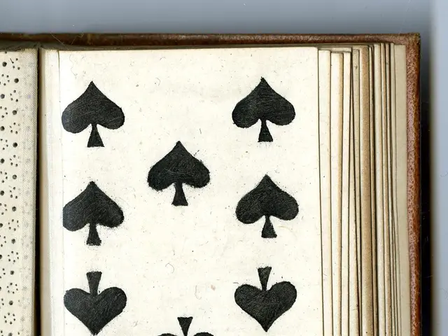 The image shows an open book with a black and white image of a deck of playing cards on it. The...
