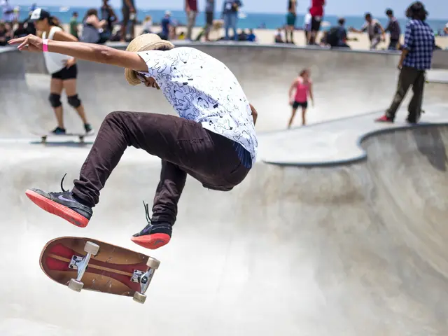 The image shows a skateboarder doing a trick in the air at a skate park, surrounded by a group of...