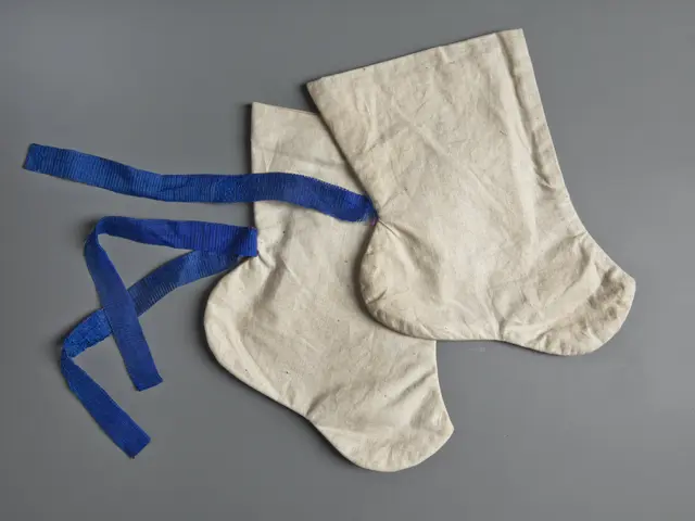 The image shows a pair of white socks with blue ribbons tied around them, creating a festive...