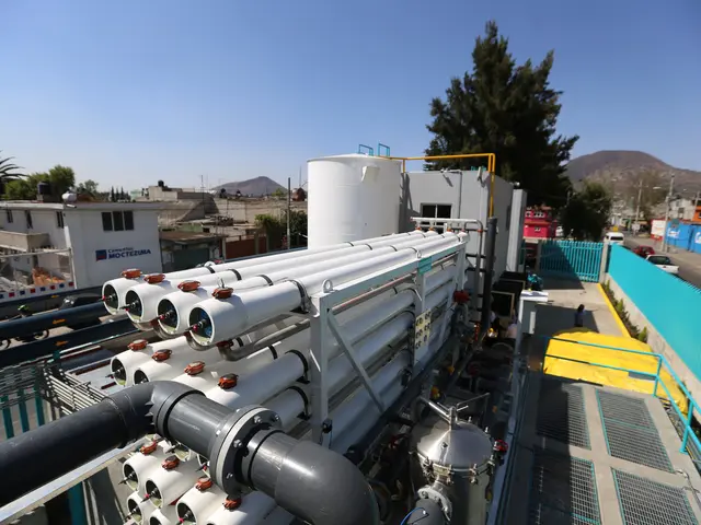 The image shows a large group of pipes sitting on top of a building, surrounded by machines,...