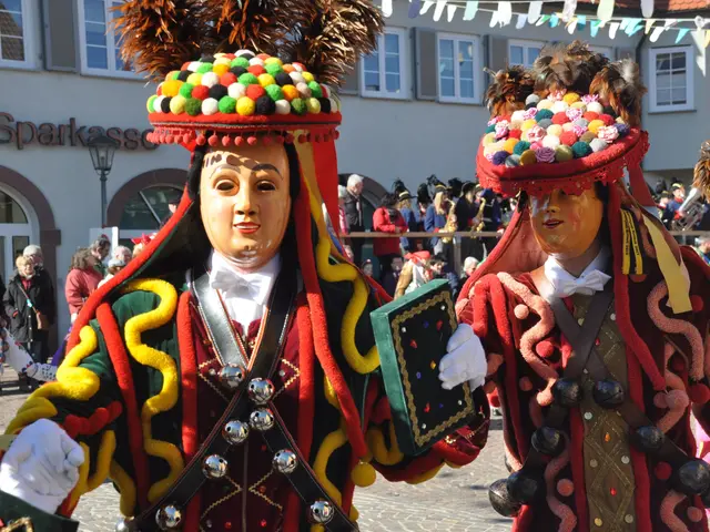 The image shows a group of people in colorful costumes walking down a street, with a building in...
