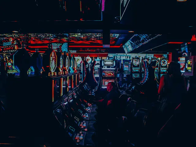 The image shows a group of people playing slot machines in a casino. There are people sitting on...