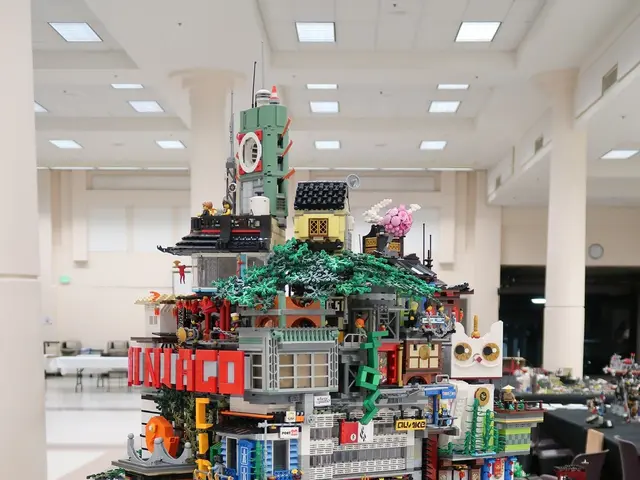 The image shows a large Lego Christmas tree made out of Legos on a table, surrounded by toys,...