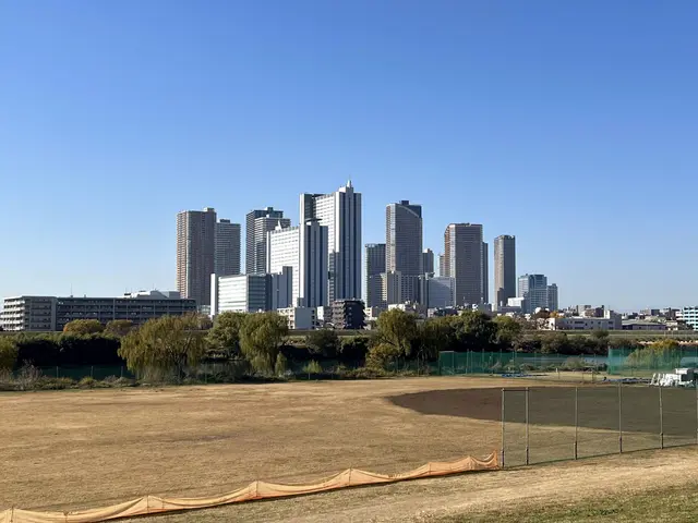 The image shows a baseball field with a city skyline in the background, featuring skyscrapers,...