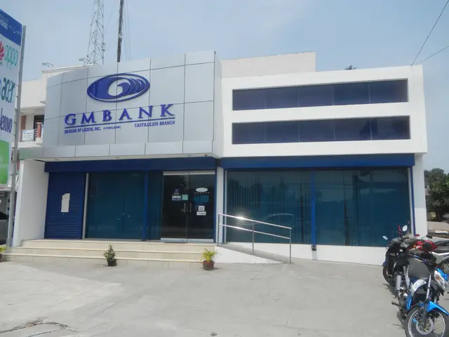 The image shows a building with glass walls and doors, steps with railings, pots with plants,...