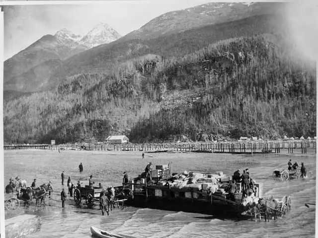 The image shows a black and white photo of a group of people on a boat in the water, surrounded by...