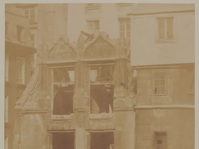 The image shows an old photo of a building with a lot of windows, and at the bottom of the image...