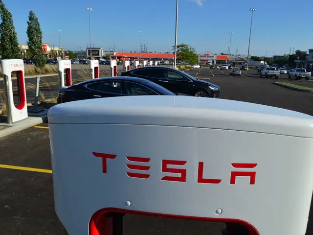 The image shows a Tesla charging station in Fremont, California, with cars parked in the parking...