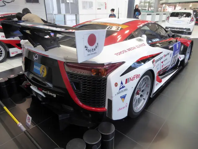 The image shows a Toyota Supra GT3 race car on display at the Tokyo Motor Show. There are several...
