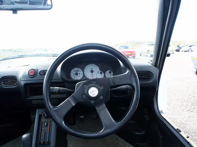 The image shows the interior of a car with a steering wheel, dashboard, speedometer, gear rod,...