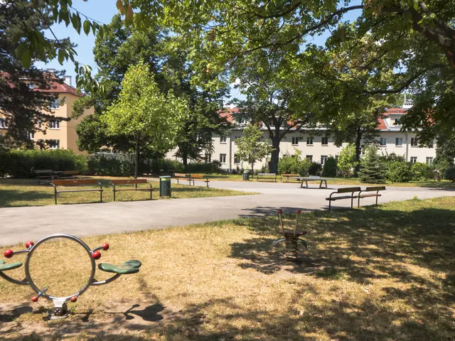The image shows a park with a playground in the middle of it, surrounded by trees, benches,...