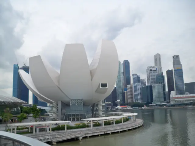 The image shows the Marina Bay Sands Hotel in Singapore, with its iconic lotus flower-shaped...