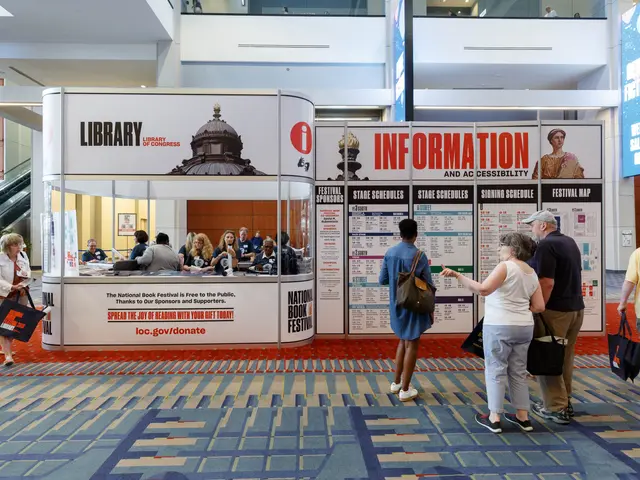 The image shows a group of people standing in front of a booth at the National Book Festival. Some...