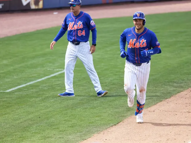 The image shows two baseball players running to first base during a game. They are both wearing...