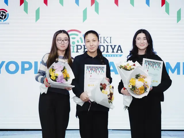 The image shows three women standing next to each other on a stage, each holding a bouquet of...