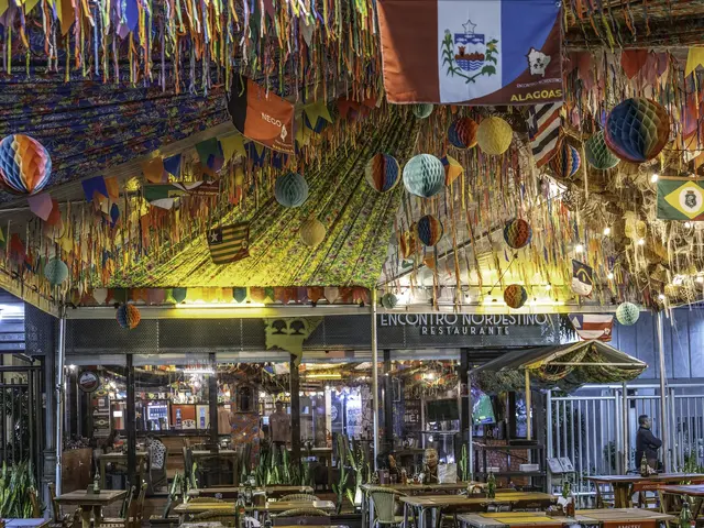The image shows a restaurant with tables and chairs in the middle of it, surrounded by bottles and...