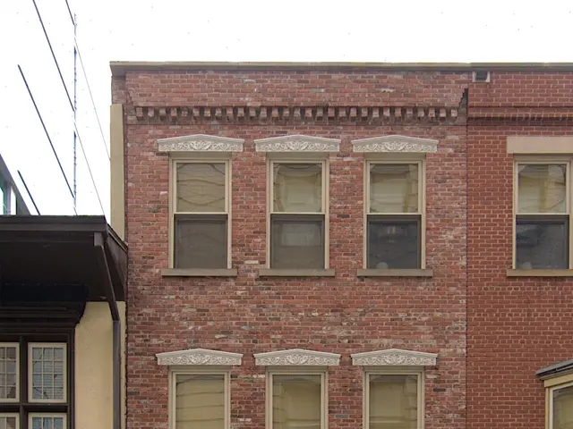 The image shows a building with glass windows and doors, a name board with the words "Residences at...