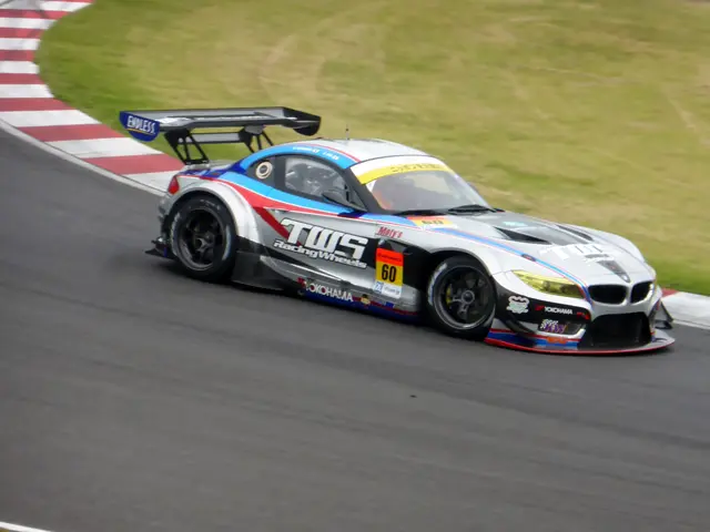 The image shows a BMW Z4 GT3 race car driving on a race track, with text and numbers on the car and...