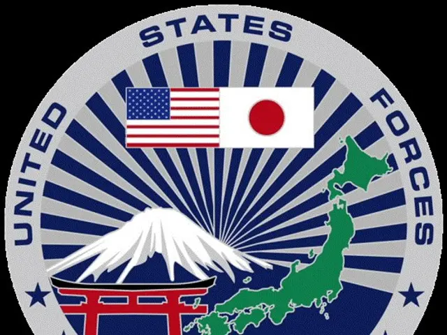 The image shows the United States Forces Japan logo, which consists of a blue circle with a white...