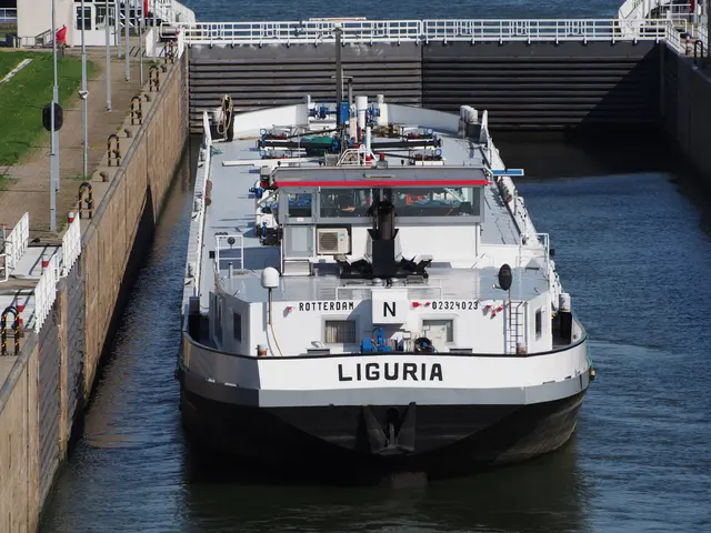 The image shows a large boat traveling through a lock on a river, with a wall on the left side of...