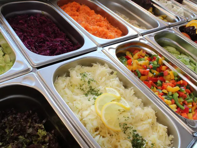 The image shows a buffet filled with lots of different types of food, including a salad bar. The...