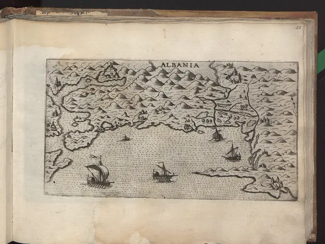 The image shows an open book with a drawing of a map of Albania on it, set against a dark...