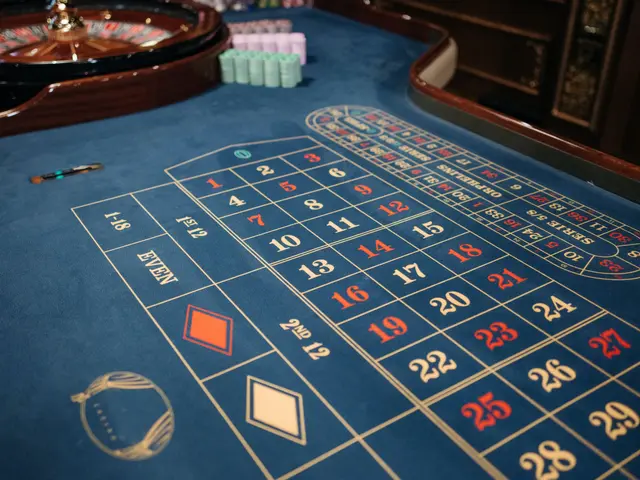 The image shows a roulette table in a casino, with a blue cloth covering the table and a spinning...