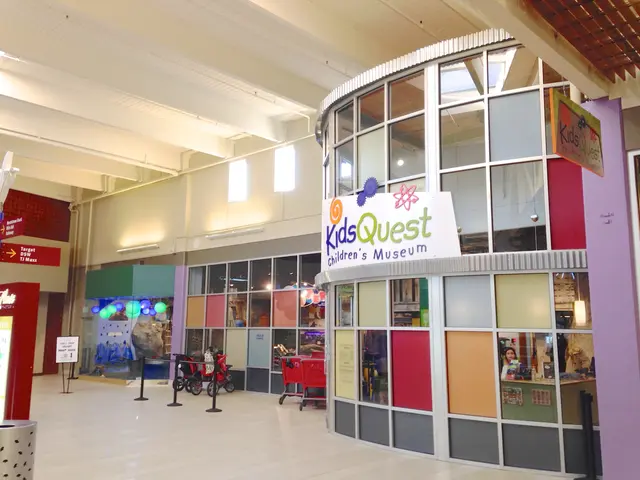 The image shows the inside of a shopping mall with a sign that reads "Kids Quest Children's...