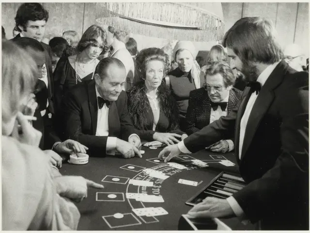 The image shows a group of people sitting around a blackjack table, with cards spread out in front...