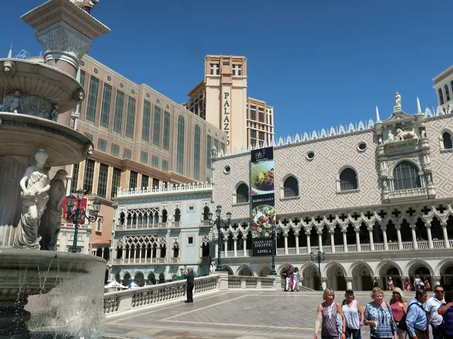 The image shows the Venetian Hotel and Casino in Las Vegas, Nevada. There are many people walking...